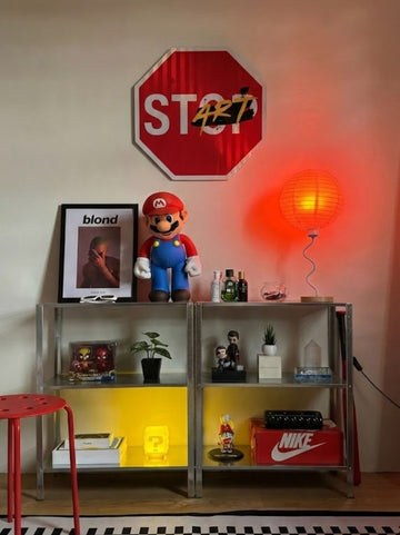 Room interior with a shelf displaying various items, including a 'stop' street sign.