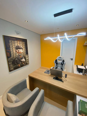 Modern office space with a desk, chairs, and a painting on the wall.