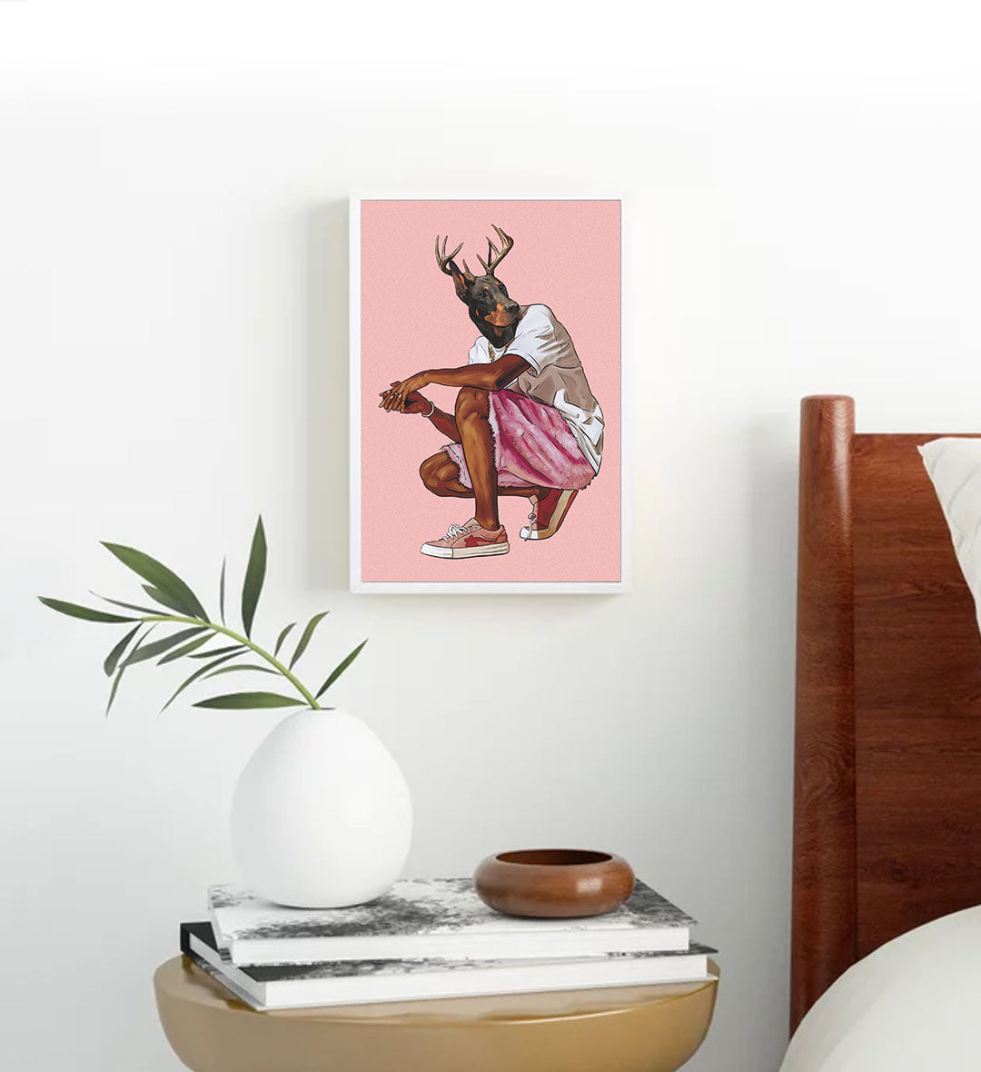 Framed artwork of a dog with antlers on a pink background.