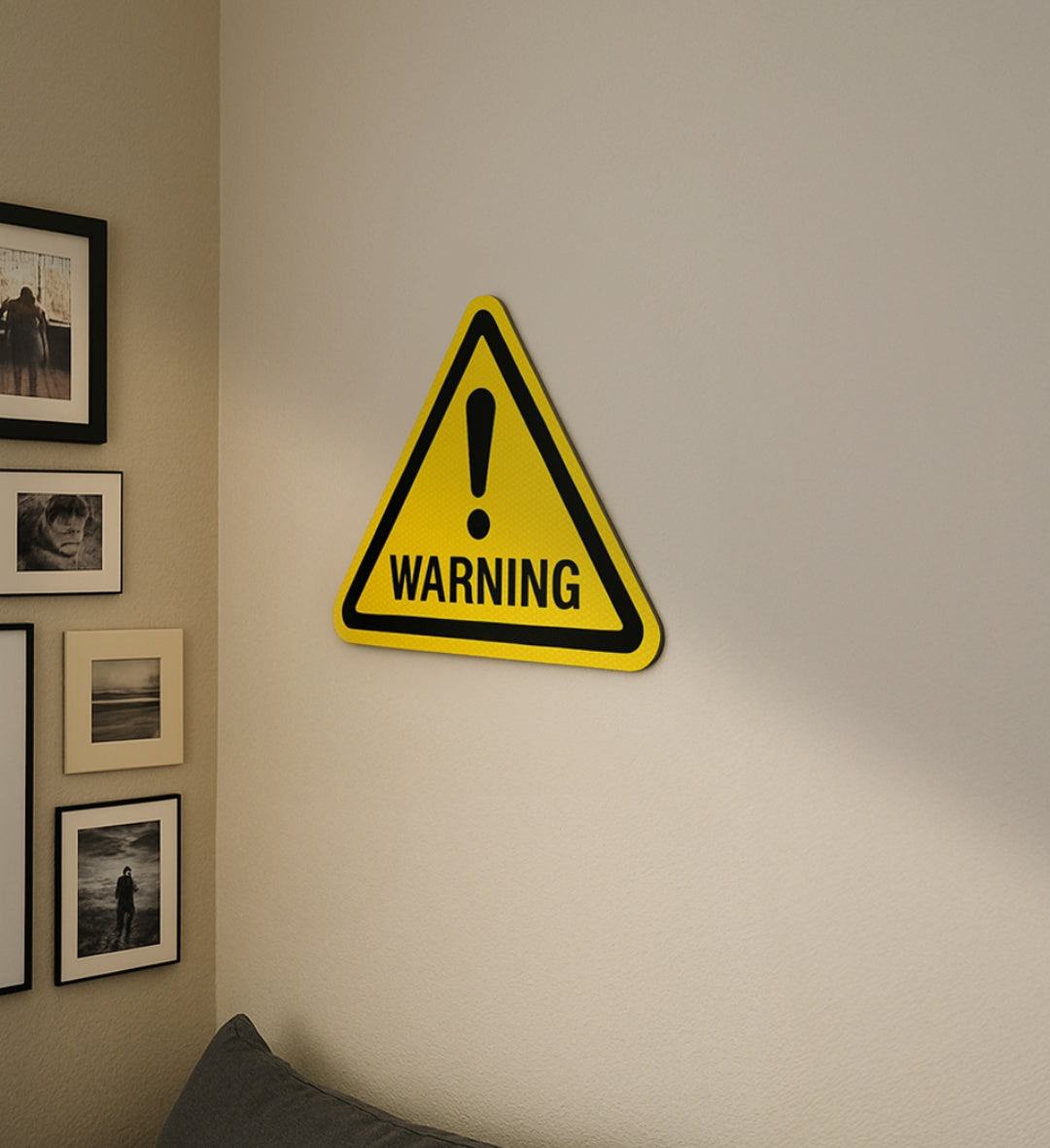 Yellow warning road sign with black border and exclamation mark on a beige wall for modern home decor.