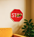 Red stop sign with 'STOP' and 'START' text on a beige wall.