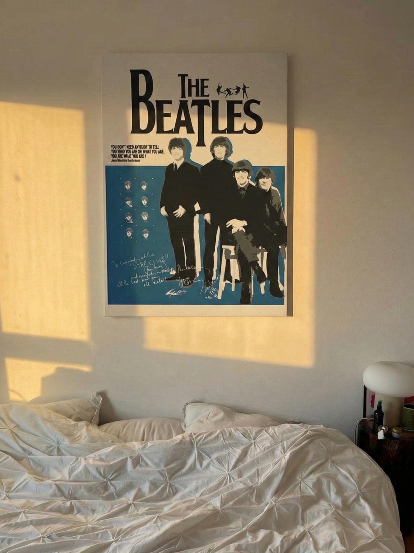 canvas of The Beatles on a wall above a bed